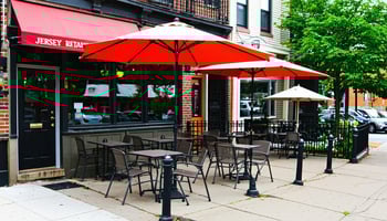  A patio with tables and umbrellas outside a Jersey City eatery