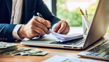 Business owner comparing term loans and revolving credit on laptop.