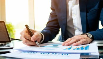  Business owner reviewing a loan agreement and financial documents.