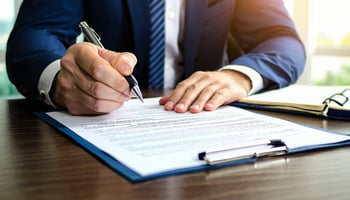 Business owner signing a commercial real estate loan application.