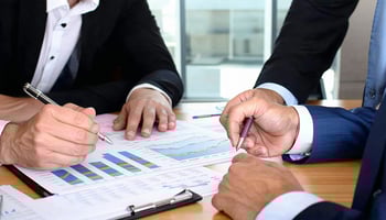 Entrepreneurs reviewing a budget with a financial advisor before applying for a business loan.