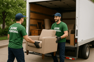 Junk removal crew loading furniture into a leased box truck.