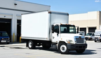 Leased white box truck parked outside a small delivery warehouse