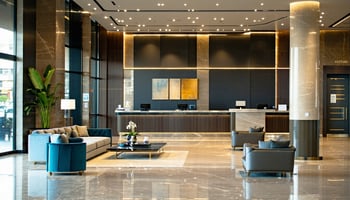 The image depicts a modern hotel lobby, featuring sleek, contemporary furnishings and a warm, inviting atmosphere. 