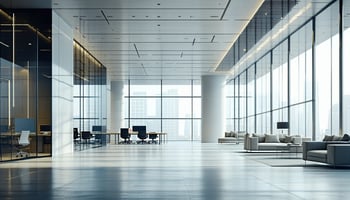 A sleek, modern office environment featuring bright natural light streaming through large windows, with contemporary furniture and a spacious layout.