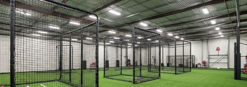 Indoor batting cage facility with pitching machines and netting - batting cage business loans