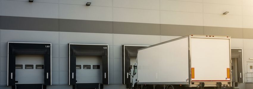 A business owner standing next to a financed box truck on a city street