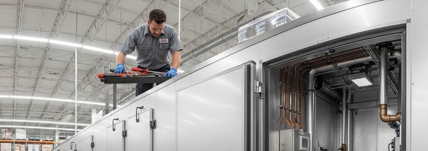 Commercial refrigeration technician working on a walk-in cooler unit