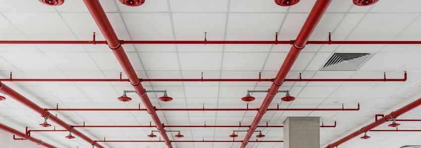 Fire sprinkler pipes and sprinkler heads installed on commercial building ceiling