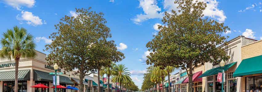 Small business district street in Lafayette, Louisiana with storefronts and palm trees