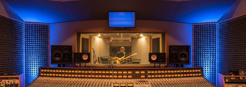 Professional recording studio control room with mixing console, monitors, and acoustic panels — music studio business loans