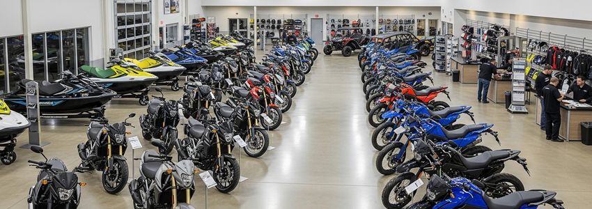 Powersports dealership showroom with motorcycles, ATVs, UTVs, and watercraft on display