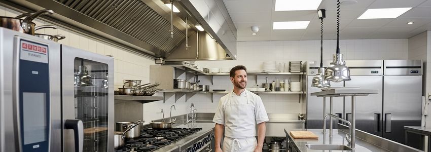 Restaurant owner reviewing commercial kitchen equipment available for leasing