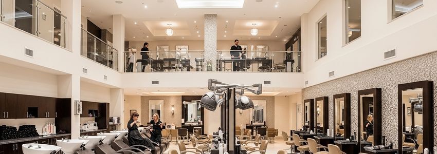 Professional beauty salon interior showing rows of modern styling chairs and salon stations