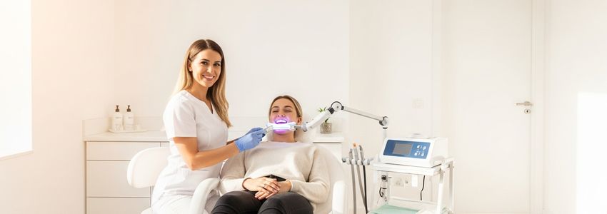 Dental professional performing teeth whitening treatment in a modern studio