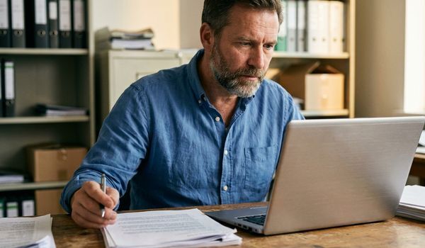 Small business owner reviewing loan application paperwork at an office desk