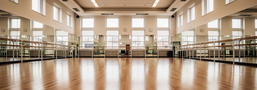 Professional dance studio with hardwood floors, ballet barres, and mirrors
