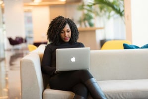 Woman working on a laptop at a desk, reviewing business information and managing tasks online.