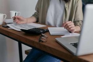 Small business owner writing on loan documents at her desk