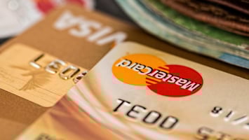 Close-up view of credit cards with Mastercard and Visa logos placed next to a wallet.