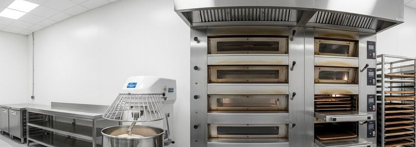 Commercial bakery equipment including mixers and ovens in a professional bakery