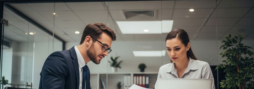 Small business owner and financial advisor reviewing business improvement financing options at a modern office