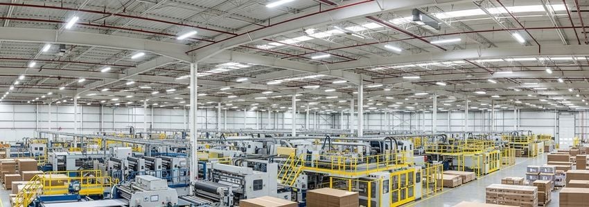 Box manufacturing facility interior showing industrial machinery and corrugated cardboard production lines