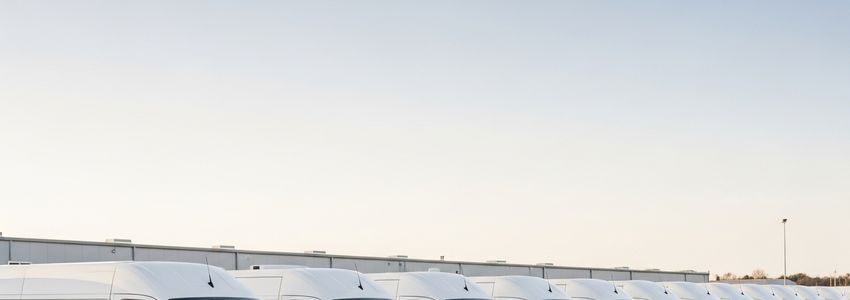 Fleet of cargo vans and delivery vehicles parked in a commercial fleet yard