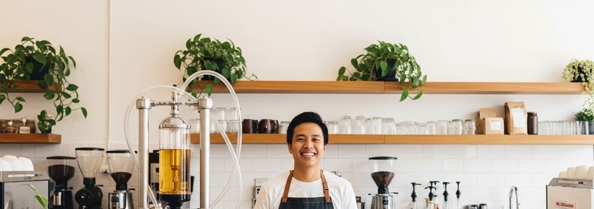 Cold brew coffee shop owner behind the counter with brewing equipment
