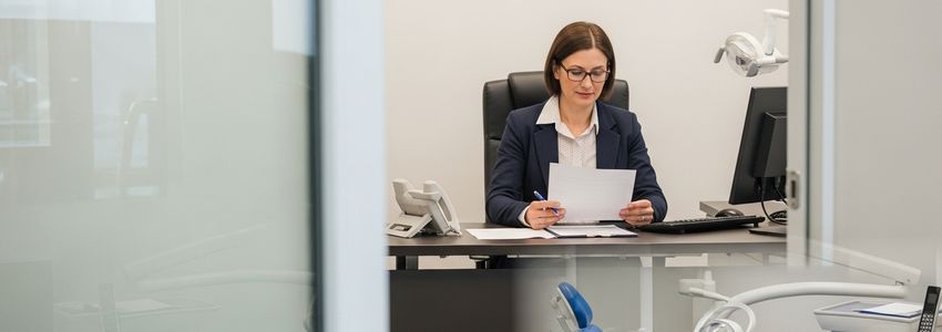Dental practice owner reviewing equipment financing options for dental chair leasing vs buying