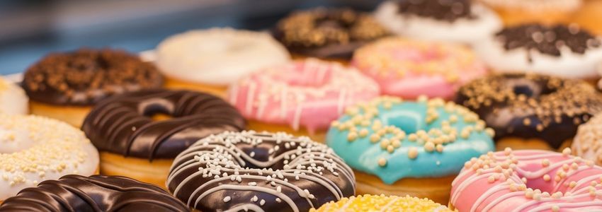 Colorful Duck Donuts franchise display case showing fresh made-to-order donuts with various toppings and glazes