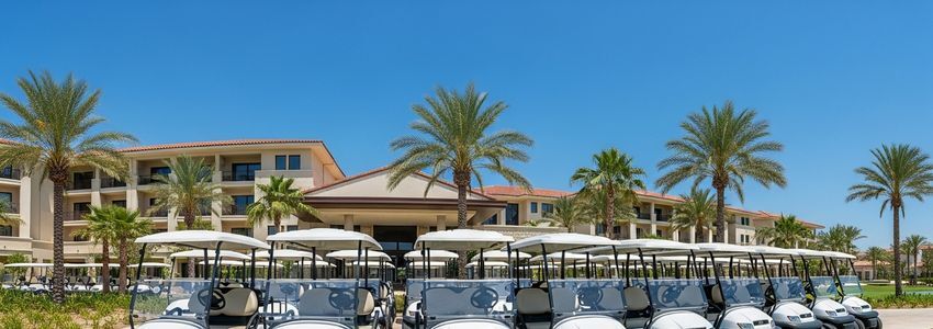 Fleet of electric golf carts parked at a luxury resort, illustrating golf cart leasing options for resorts and complexes