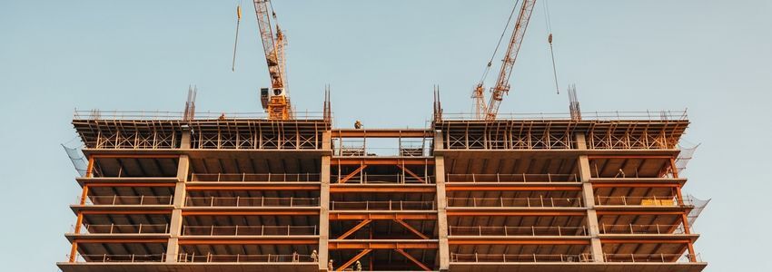 Commercial construction site with steel framing and cranes representing ground up construction loan financing