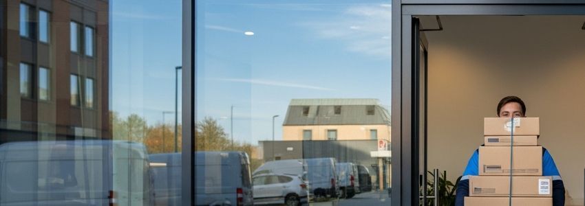 Delivery person carrying packages at business doorstep - last-mile delivery financing