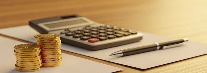 Business owner calculating total loan cost on a laptop at a modern office desk