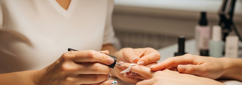 Nail technician performing professional manicure service at a nail salon