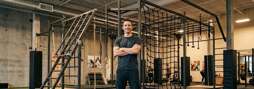 Obstacle course rig and warped wall equipment installed inside a ninja warrior training gym