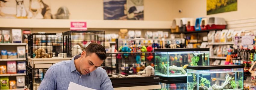 Petland franchise owner reviewing business loan documents in a pet store