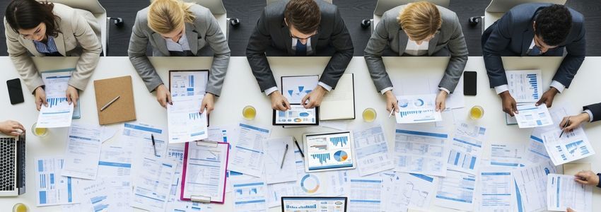 Business team reviewing purchase order and invoice financing documents in a professional office meeting