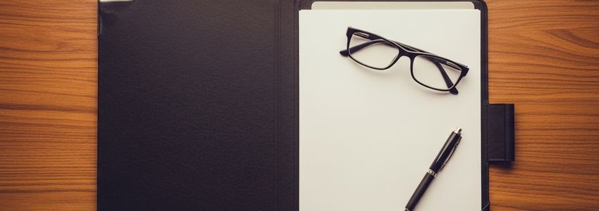 Business documents and reading glasses for reviewing APR on a business loan