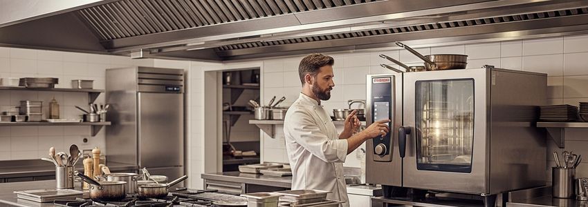 Professional chef operating commercial cooking equipment in a restaurant kitchen