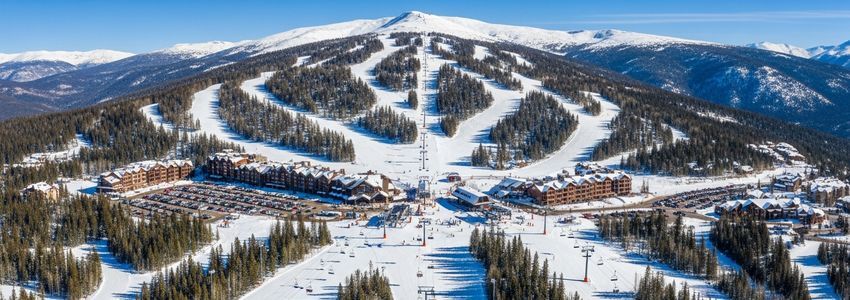 Aerial view of a ski resort showing chairlifts, groomed runs, and base lodge facilities