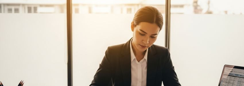 Tour company business owner reviewing loan documents with financing specialist in a professional office setting