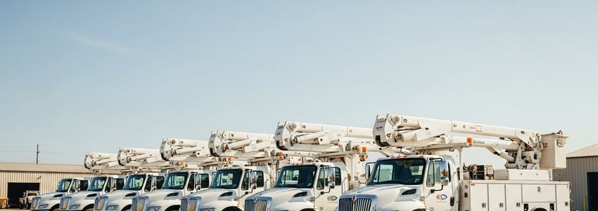 Fleet of utility trucks parked at a commercial depot - utility truck financing for business