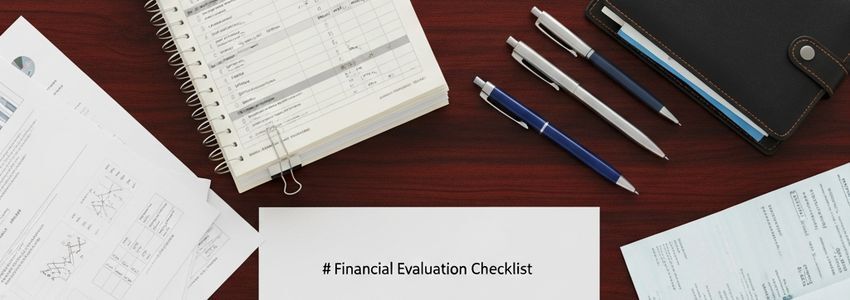 Loan application evaluation checklist with financial documents on desk