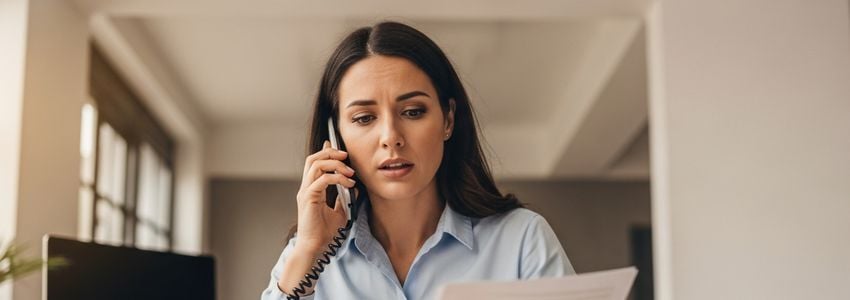 Business owner on the phone reviewing documents related to business credit identity theft