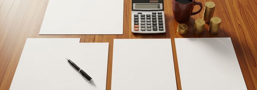Business desk with financial documents, calculator, and pen representing business loan planning and financial decision-making