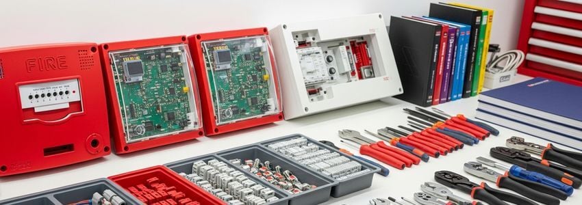 Fire alarm technician installing fire detection system in a commercial building